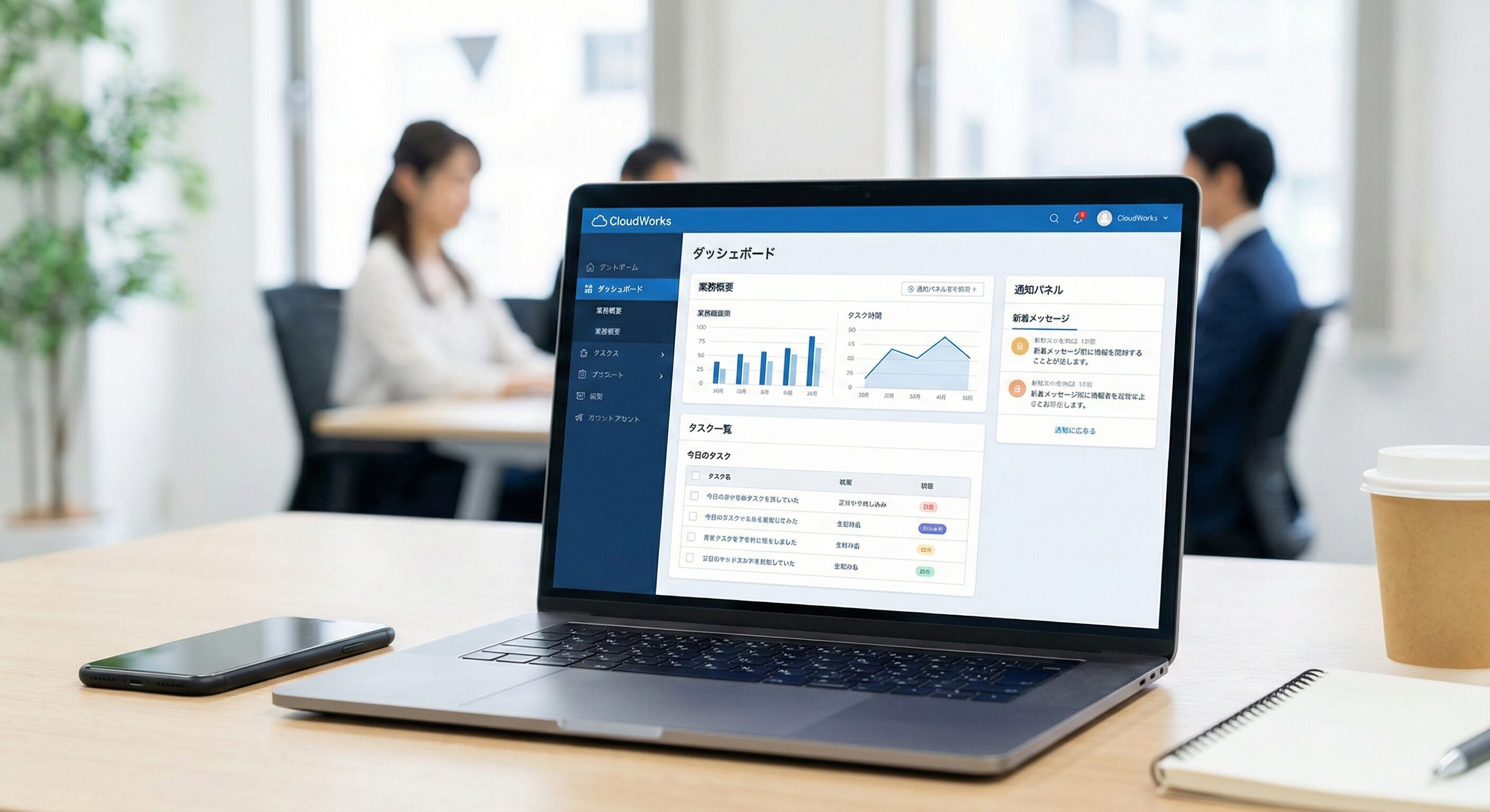 クラウドサービスの管理画面がノートPCに表示されている写真。画面には業務管理のダッシュボード、タスク一覧、通知パネルなどが表示されている。